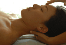 A lady relaxing on a table while receiving a massage.