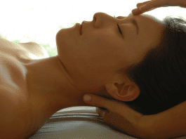 A lady relaxing on a table while receiving a massage.