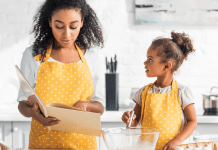 A mom and daughter in cute yellow aprons cooking together.