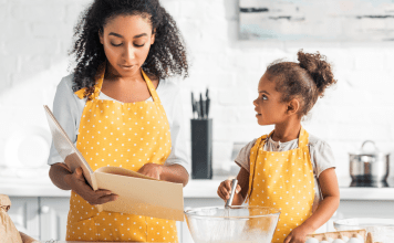 A mom and daughter in cute yellow aprons cooking together.