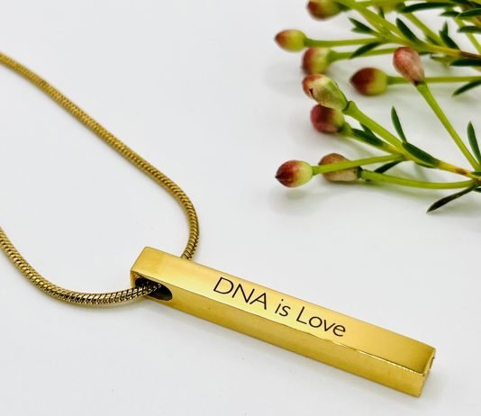 A beautiful gold piece of jewelry that says 'DNA is love'